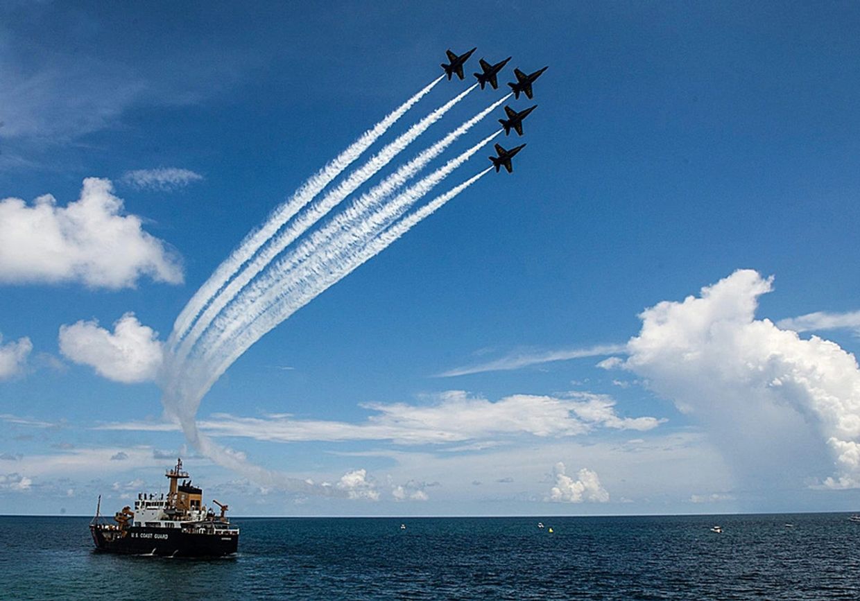 5 Blue Angel planes flying over coast guard vessel in the ocean during the Brunswick Airshow