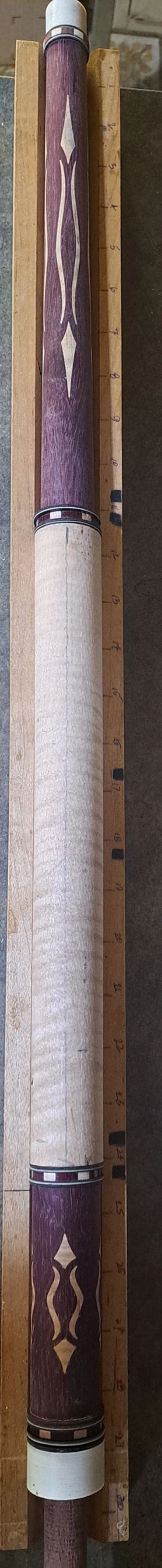 Handcrafted wooden pool cue with intricate inlay design.