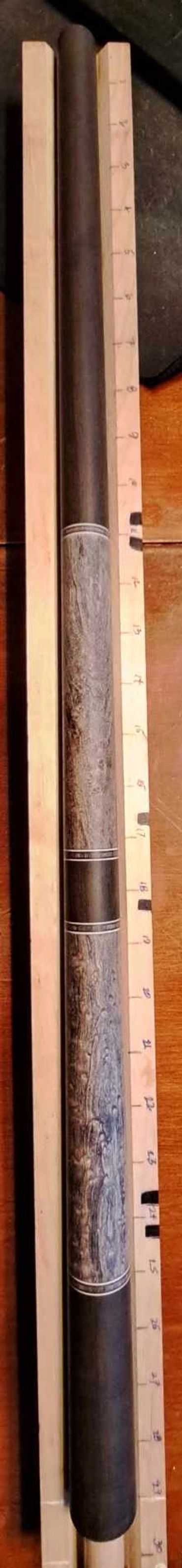 Handcrafted wooden cue stick with detailed grain patterns.