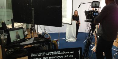 Behind the scenes of a video shoot with camera and crew.