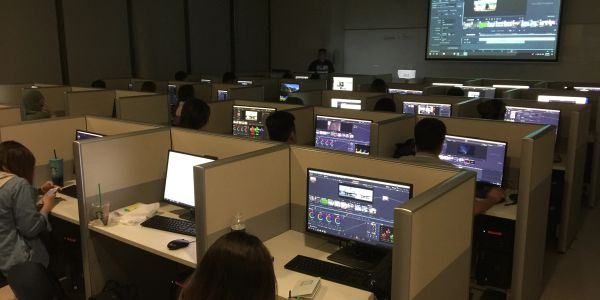 People working on computers in a dimly lit room.