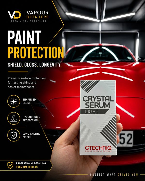 Hand holding Crystal Serum Light in front of a shiny red sports car promoting paint protection.