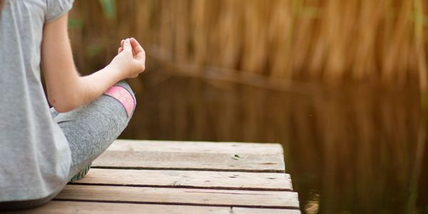 Young girl on a bench in mediation pose