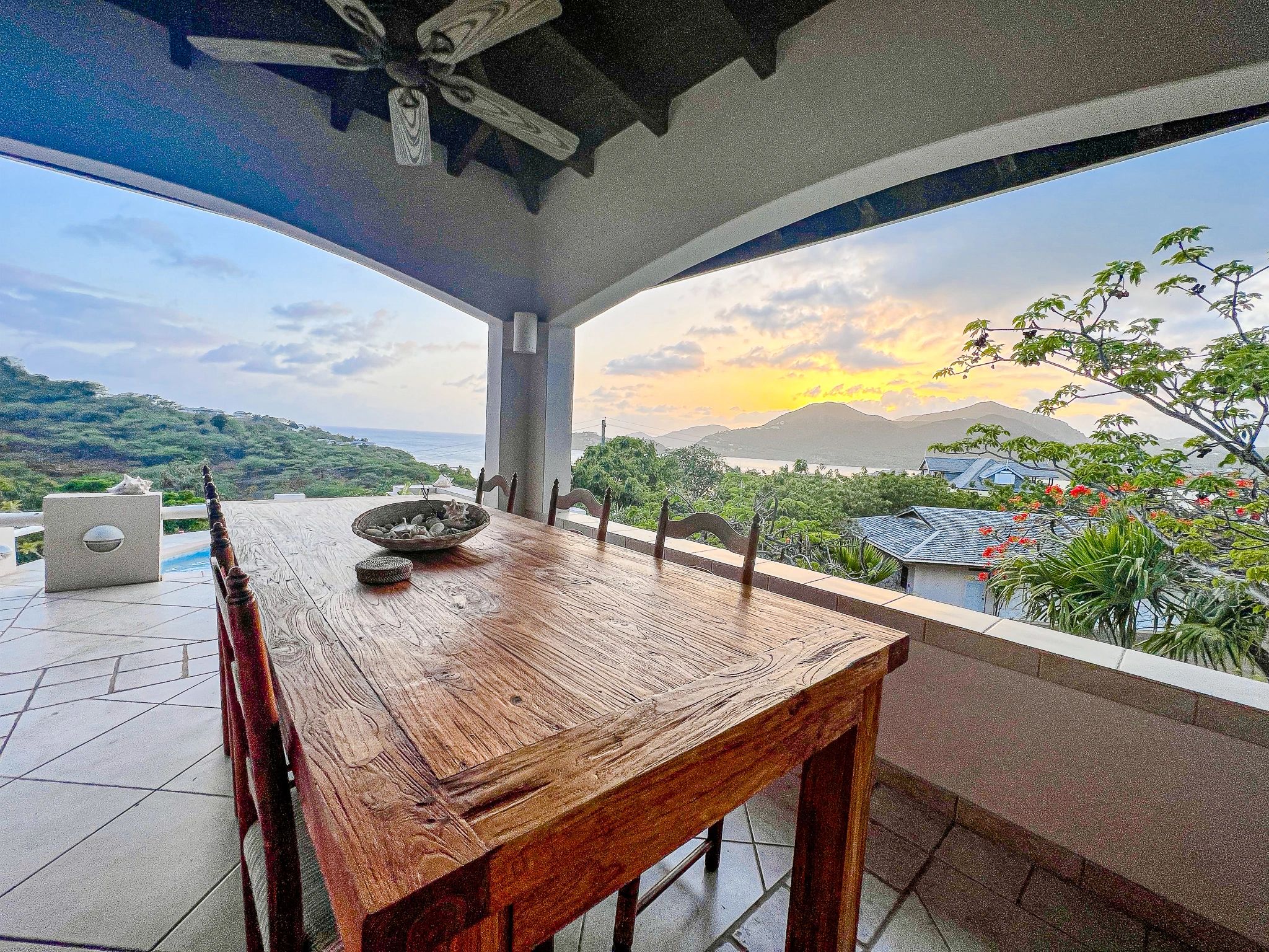 Large farmhouse dining table on covered balcony at The Garden House