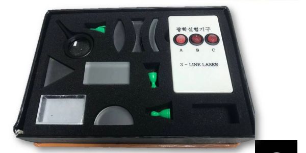 Optical experiment kit with lenses and laser controls.