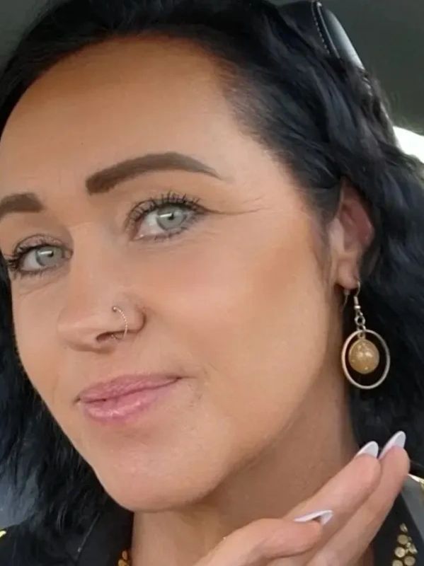 Close-up of a woman with striking blue eyes and nose ring.