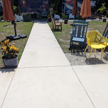 A clean common area, with a clean sidewalk that leads to a food truck park.