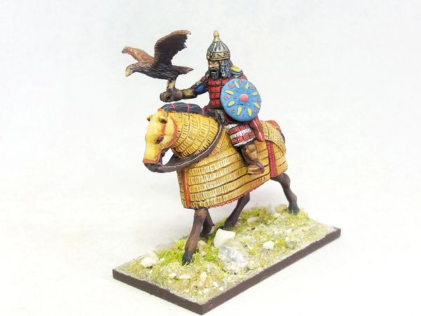 Miniature warrior on armored horse holding an eagle, detailed and colorful.