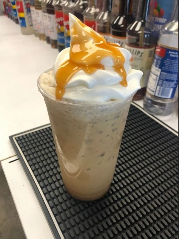 Iced coffee with whipped cream and caramel drizzle.