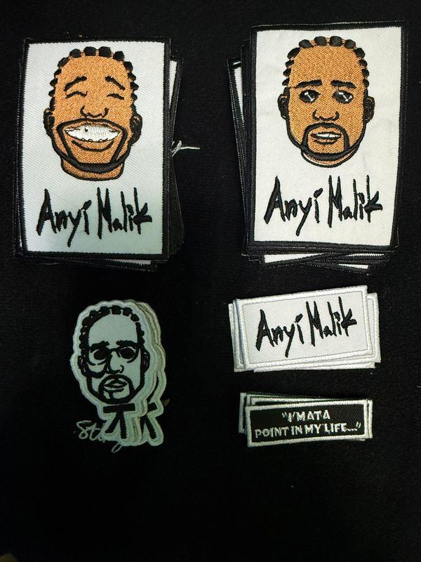Embroidered patches featuring cartoon faces and text signatures on black background.