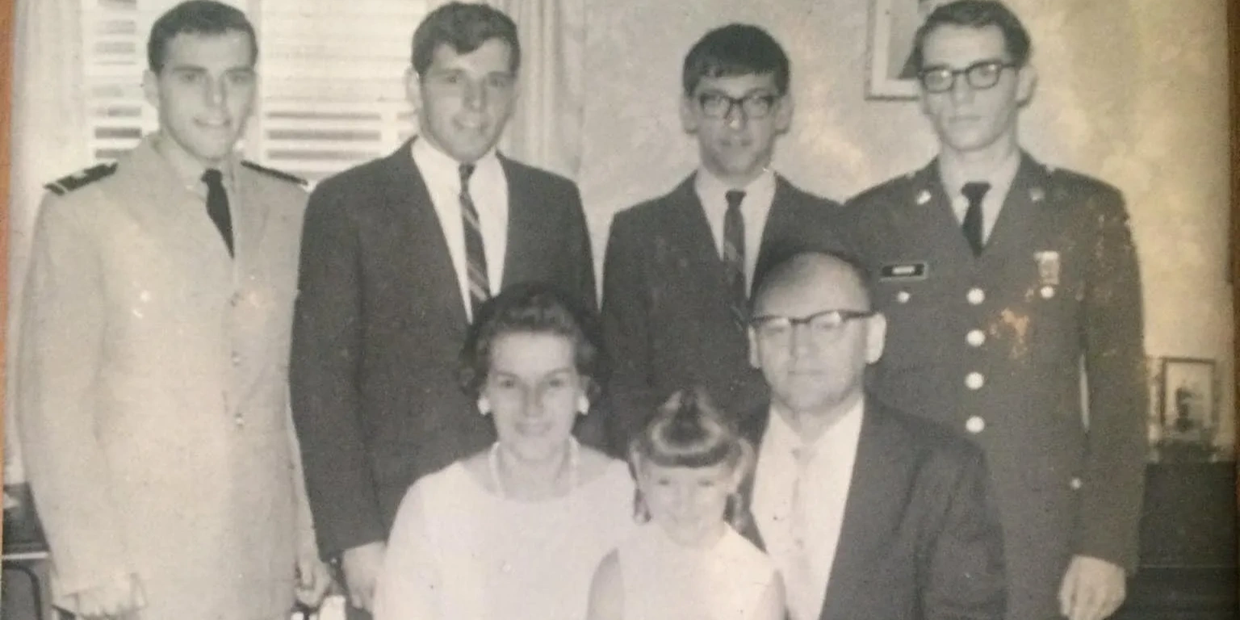 Vintage black and white family portrait with men in military and formal attire.