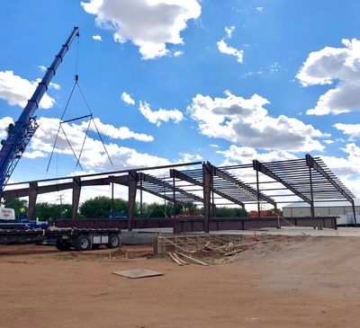 Steel frame construction for a building under a blue sky.