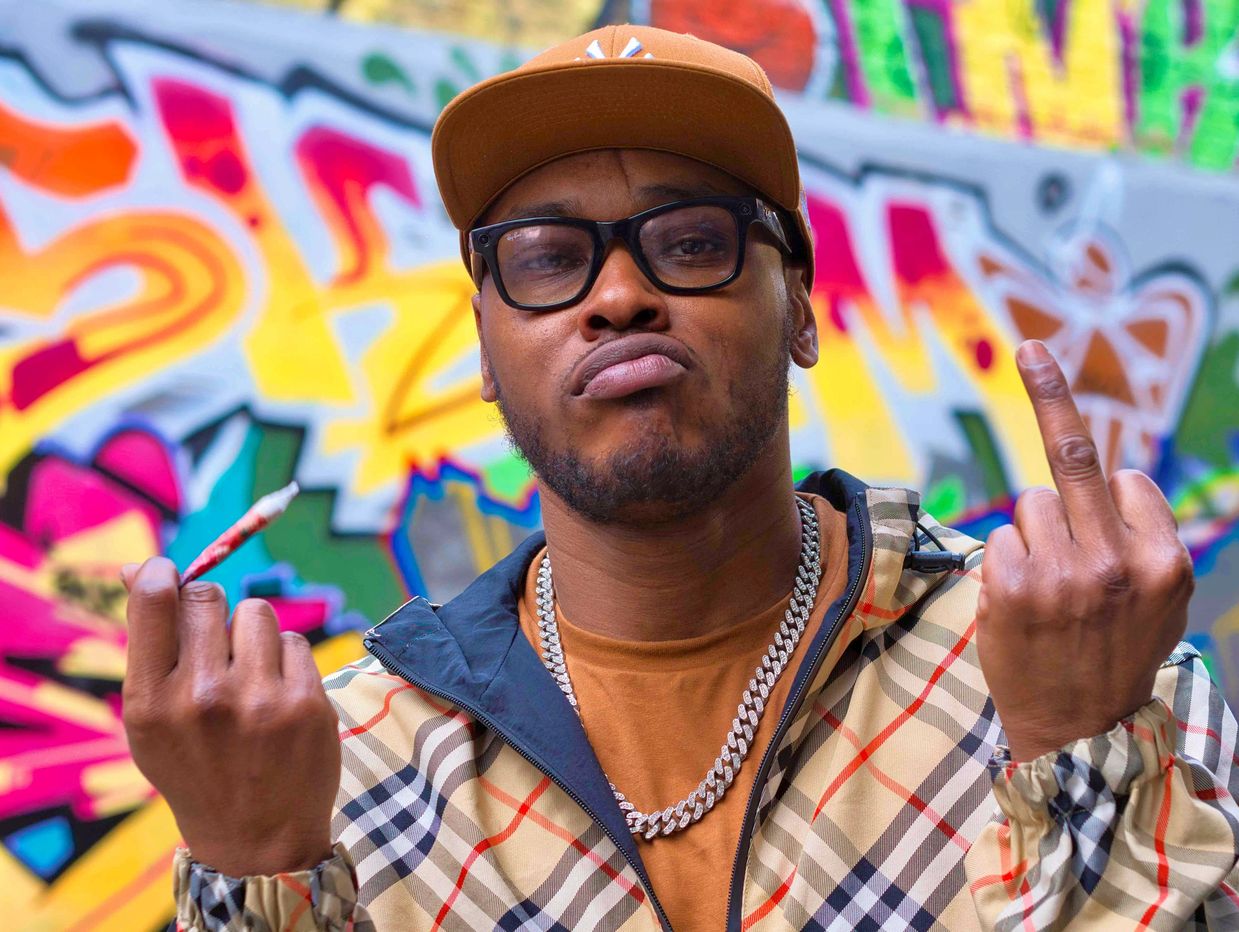 Grime Artist in front of graffiti background creative editorial portrait by flash spacey photography