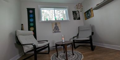 Cozy meditation corner with two chairs, a small table, and spiritual decor.