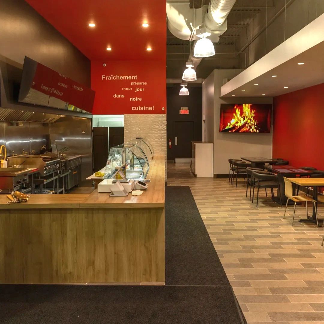 Intérieur moderne du restaurant avec cuisine ouverte et salle à manger.