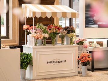 Elegant flower stand with assorted bouquets inside a stylish indoor setting.