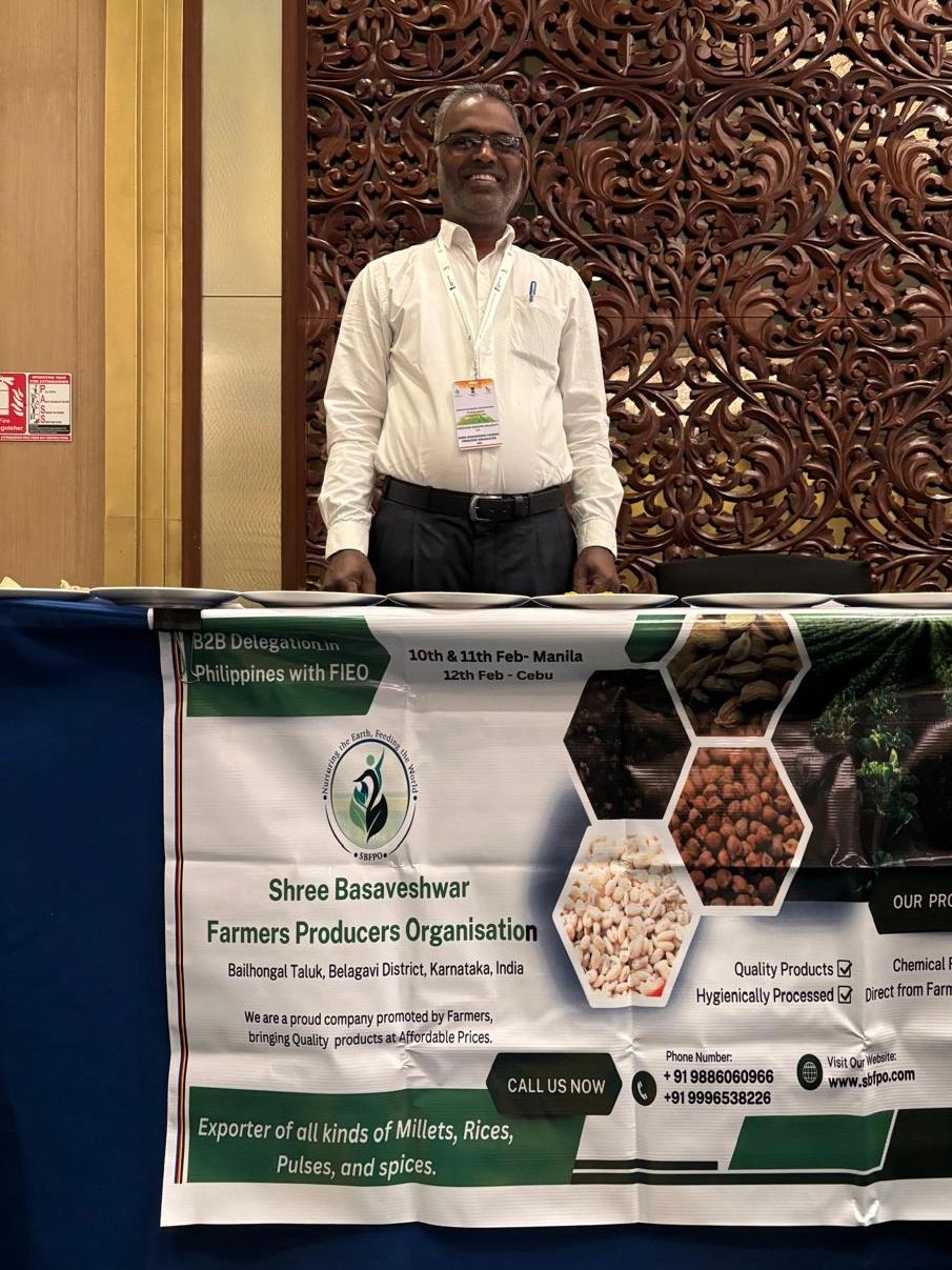 Man standing behind a promotional table for Shree Basaveshwar Farmers Producers Organisation.