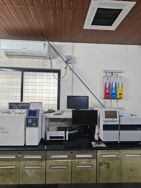 Laboratory setup with analytical instruments and computer monitors on a counter.