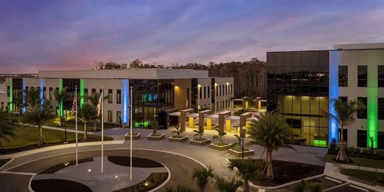 Modern office building with colorful lights at dusk.