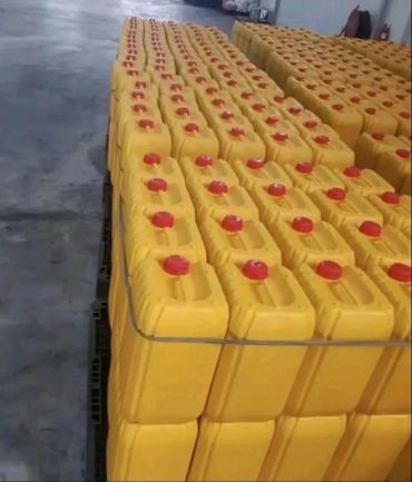 Stacked yellow containers with red caps in a warehouse.