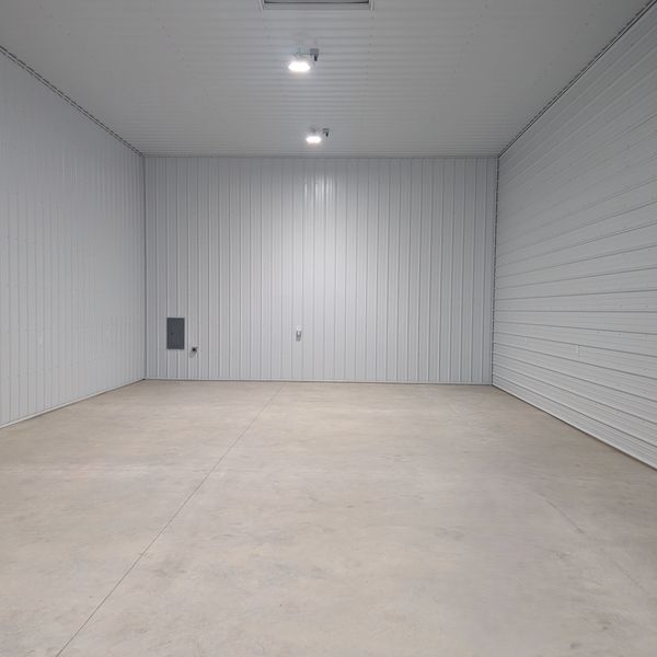 Empty industrial room with concrete floor and metal walls.