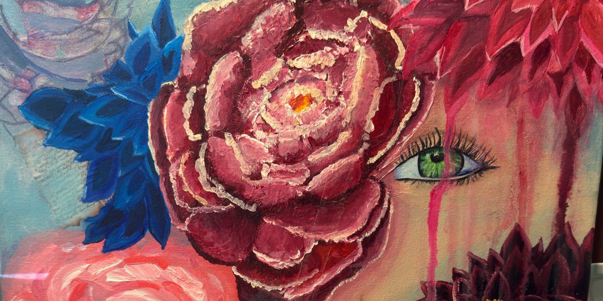 A painting of a green eye surrounded by large colorful flowers.