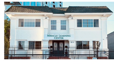 The Miracle Learning Center building with white walls and barred windows.