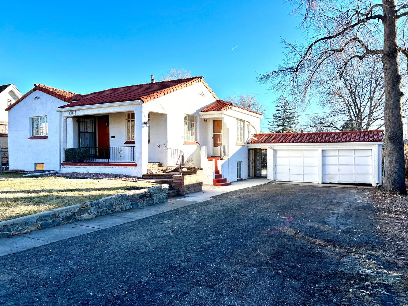 Side view with red tile roof and two-car garage.