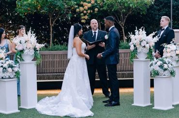 Bride and groom exchanging vows in an outdoor wedding ceremony.