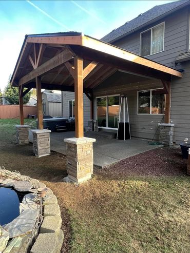 patio cover attached to house with stone wrapped posts