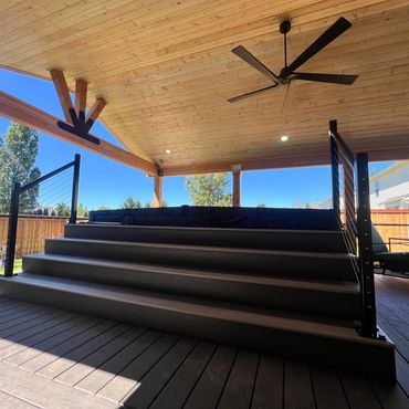 composite deck with hot tub and stairs. cable railing on composite deck with cover and hot tub