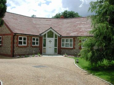 Front view of small new house with flint walls in Forest Green, Surrey.