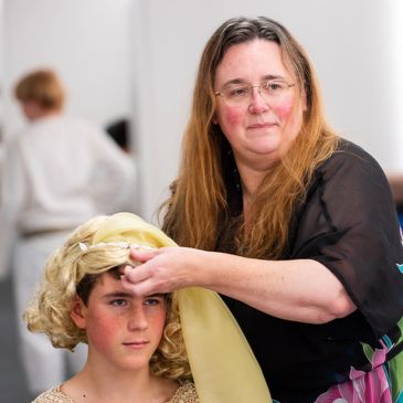 Maddy Connellan adjusting costume wig on boy at National Boys Choir concert