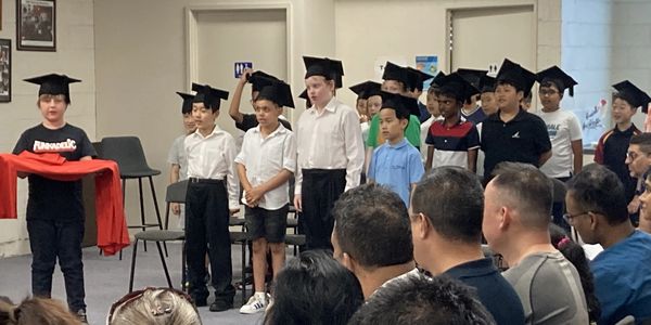 Group of boys standing in rehearsal for choir with hats on in National Boys Choir studio