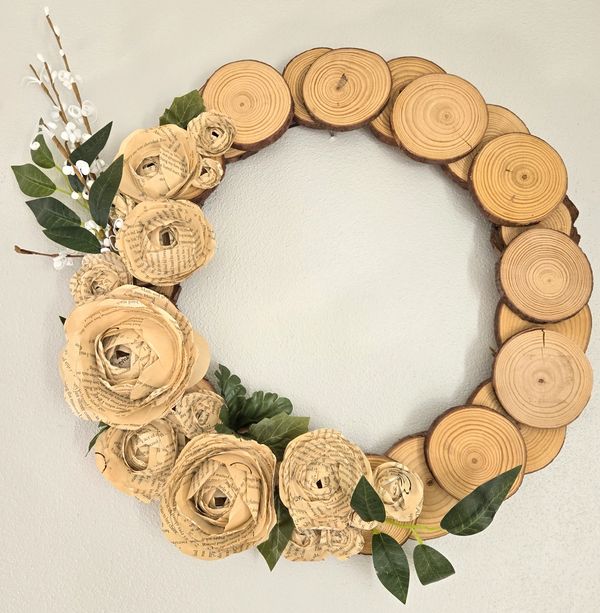 decorative wreath with wood slices and flowers made from book pages