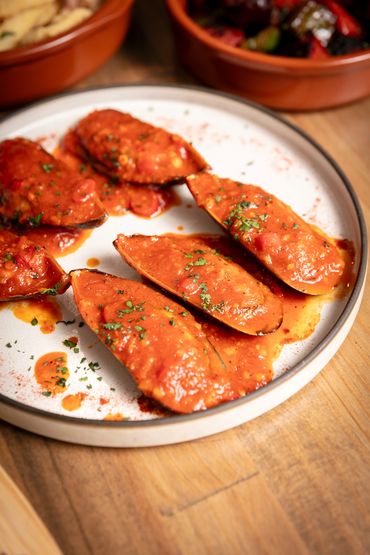 Mussels - Local mussels in a spicy fire-roasted pepper tomato sauce.