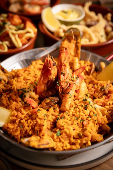 Seafood Paella - king prawns,  mussels, and calamari. Cooked with shellfish bisque and bomba rice.
