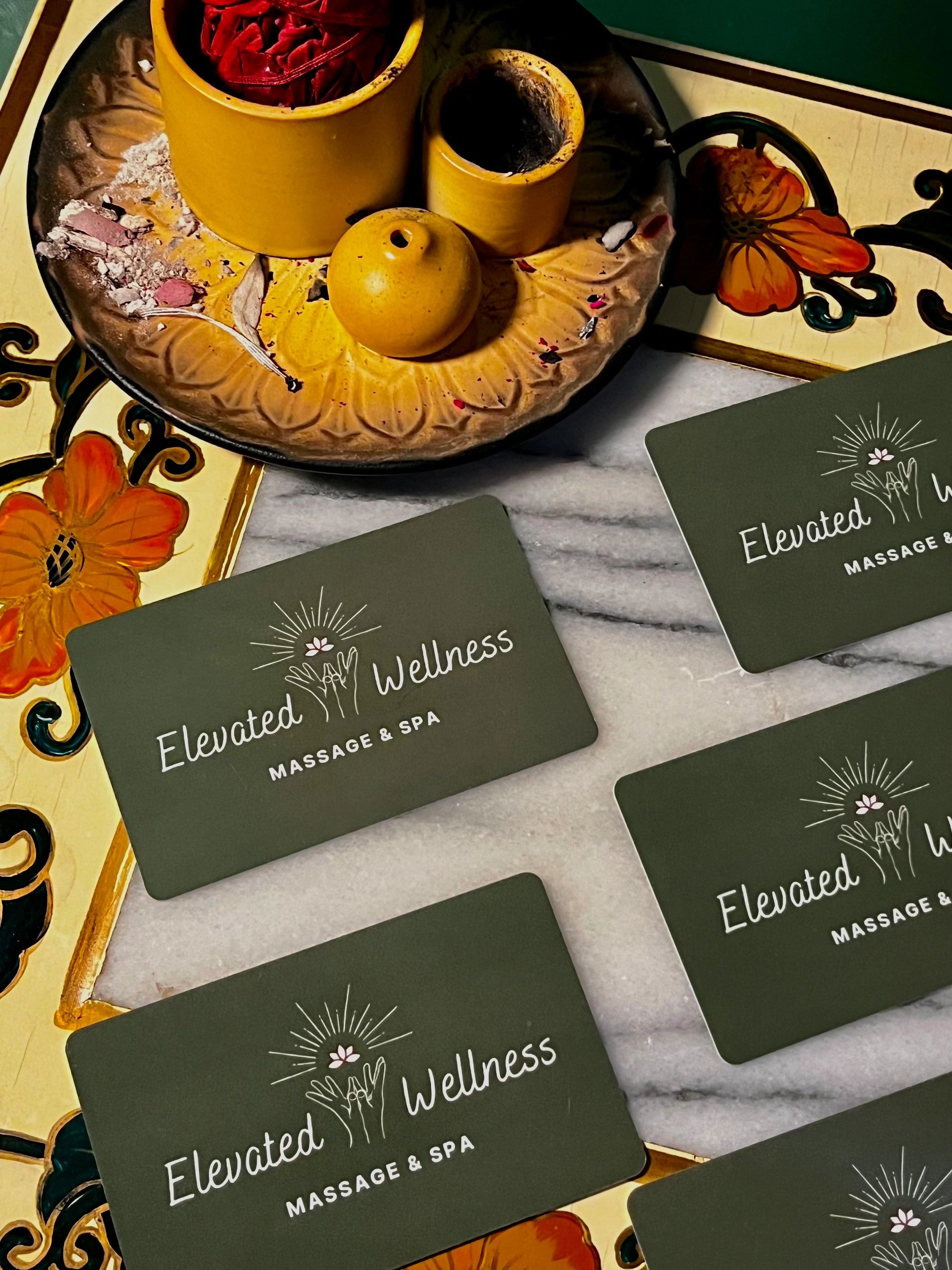 Business cards and incense setup for Elevated Wellness Massage &amp; Spa.