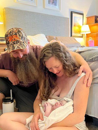 Couple smiling at their new baby after home birth.