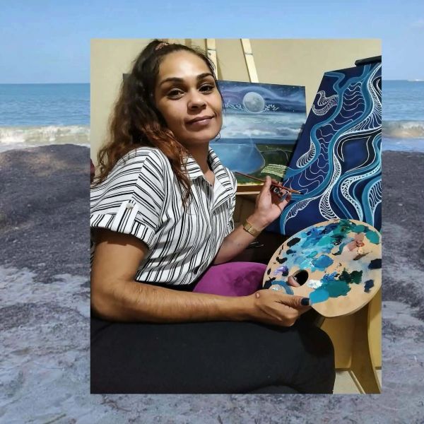 A woman painting vibrant abstract and landscape art indoors.