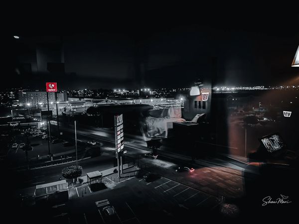 Night view of a city street with illuminated signs and buildings.