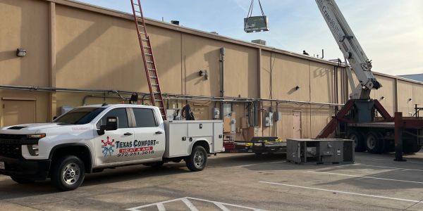 Texas Comfort Heating &amp; Air truck at a commercial HVAC installation site.