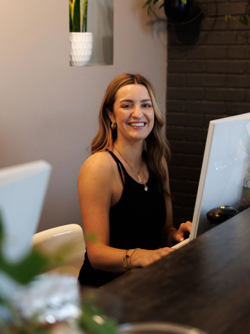 Smiling woman working at a computer in a modern office.