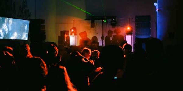 The back of a crowd, lit with warm ambient lighting 