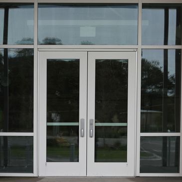 Modern glass double doors with metal frames at a building entrance.