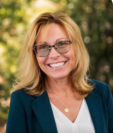 Smiling woman with glasses and blonde hair in professional attire.