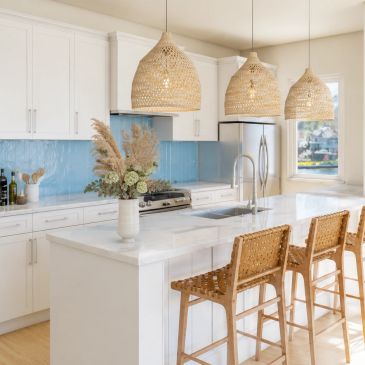 Modern kitchen with wicker stools and pendant lights.