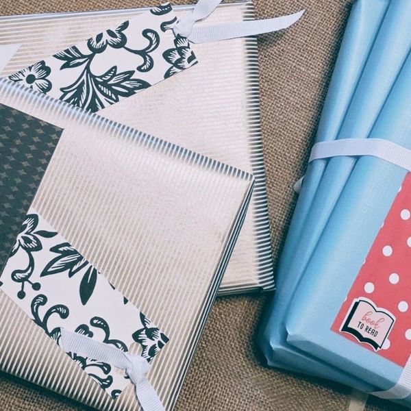 Two sets of wrapped books with decorative tags and ribbons.