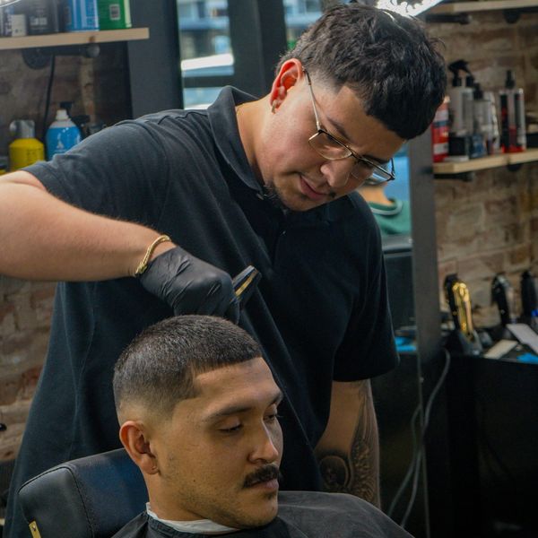 Barber giving a man a haircut in a stylish barbershop.