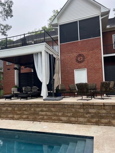 Backyard patio with pool and seating area.